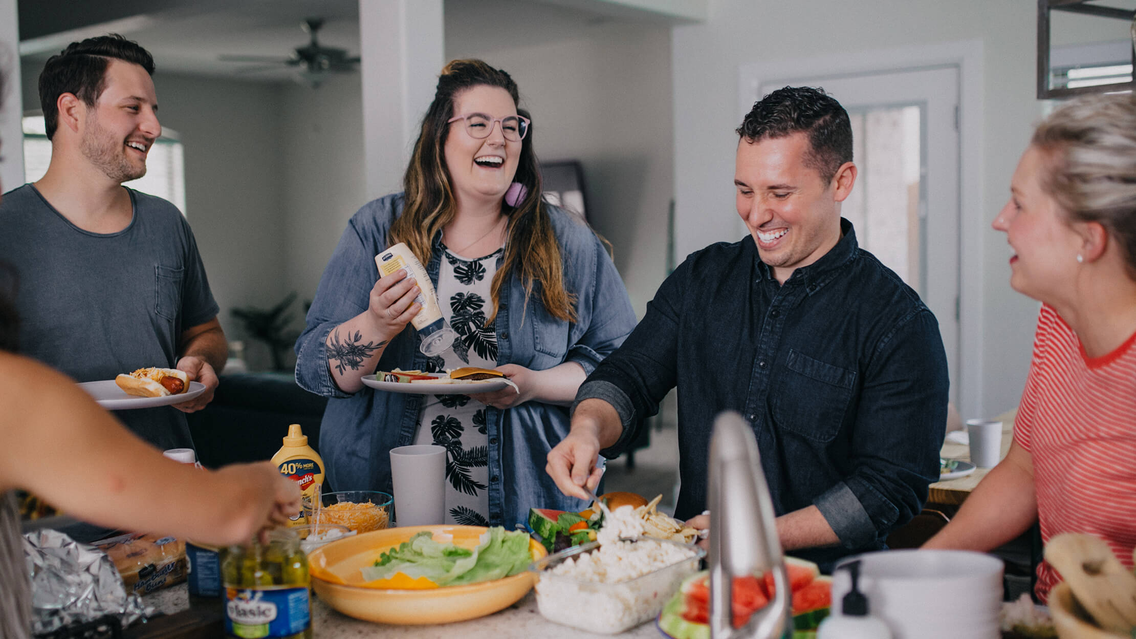 An image of people standing around a table eating, and "fellowshipping" together.
